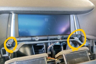 Two Torx screws at the bottom of the factory monitor