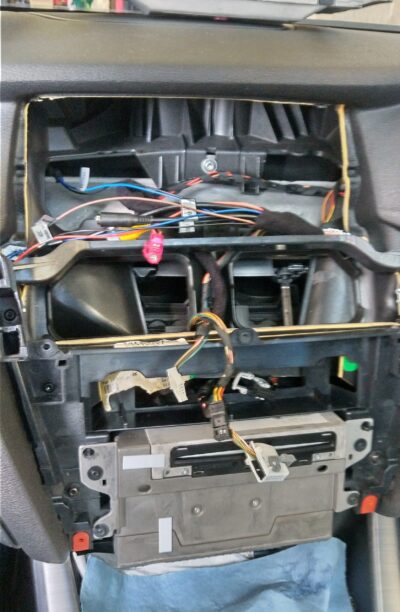 Cables routed from behind the head unit up through the center air vent area