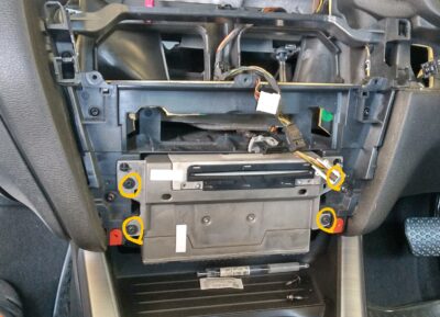 Factory navigation head unit with four Torx screws marked