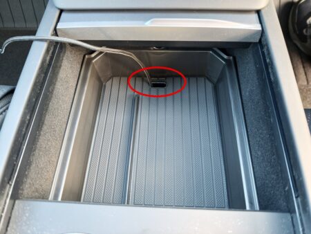 The tray installed in the front console; the red circle marks the cable slot
