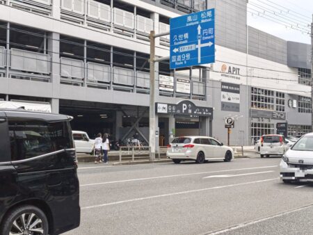 Exterior of the APIT AUTOBACS Kyoto Shijo building, with Tesla and BYD showrooms on the ground floor