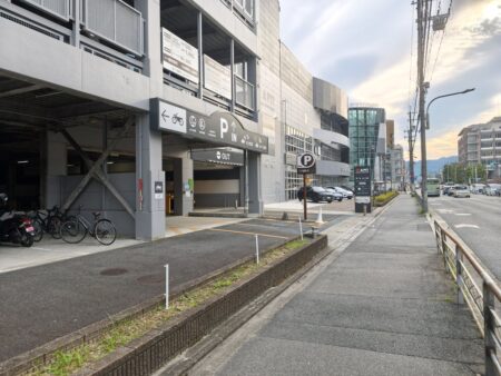 Car park entrance sign reading P IN, with EV charging on 1F and self car wash on the roof