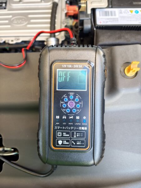 Charger clips attached to the 12V battery, display showing OFF