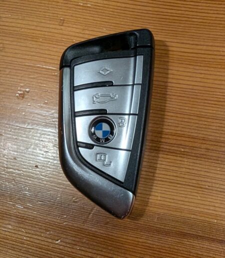 BMW G05 X5 four-button smart key on a wooden table