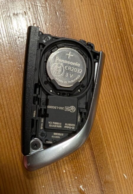 Old Panasonic CR2032 sitting in the open BMW key