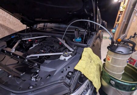 Oil extractor set up in the BMW X5 engine bay