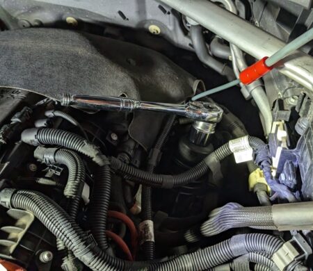 Loosening the oil filter housing cap with a 32 mm socket