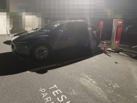 Model YL charging at a Supercharger at night