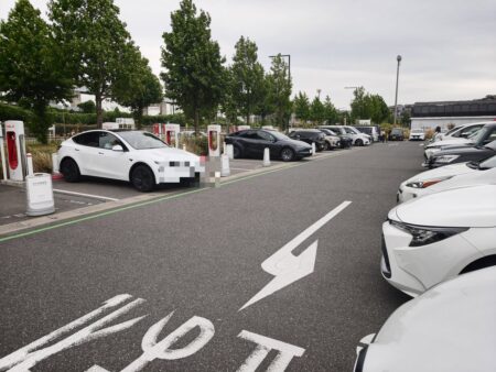 Kitakyushu Supercharger stalls, one white Tesla charging, licence plate masked