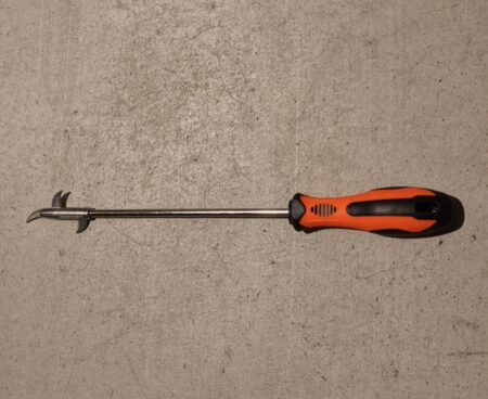 The hooked stone remover tool laid out on a concrete floor