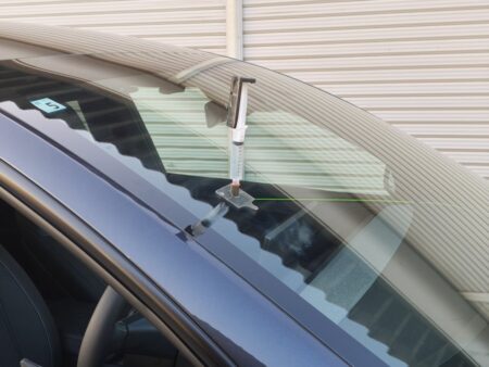 Injector fitted to the repair tool, pushing resin into the windshield crack