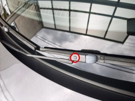 Release button circled on the old wiper before removal