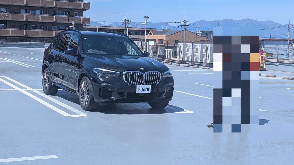 屋上駐車場で打ち合わせをするカババの査定担当者