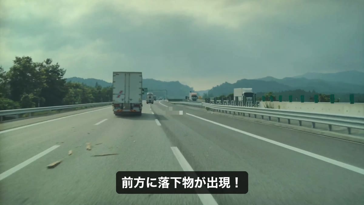 走行車線に転がる木片のような落下物。前走トラックの先に現れた