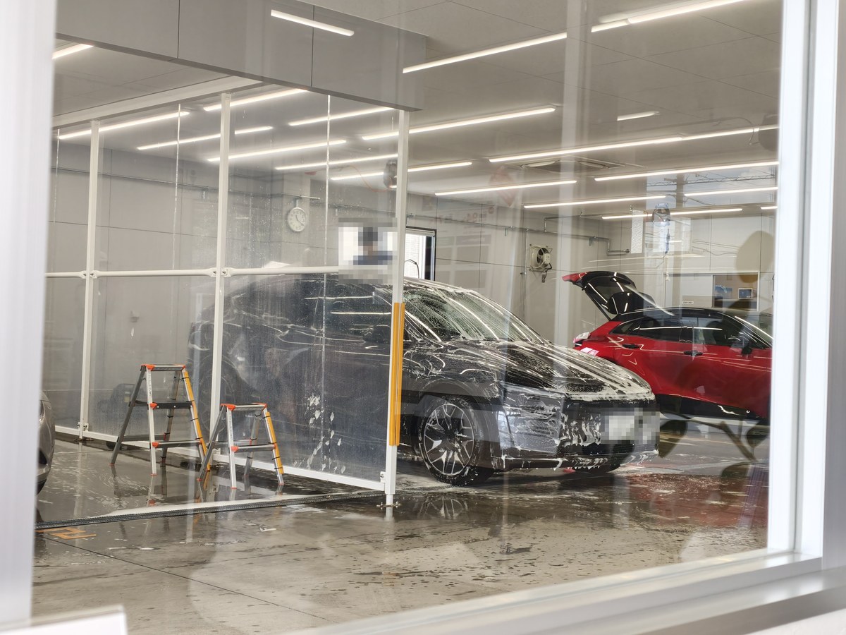 ガラス越しに見える洗車ブースとモデルYL