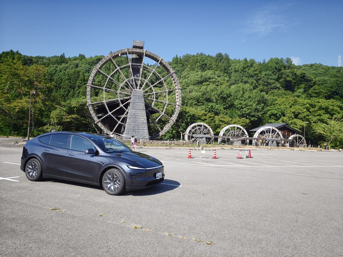 そばの里荘川に並ぶ大きな木製の水車と、停めたモデルYL