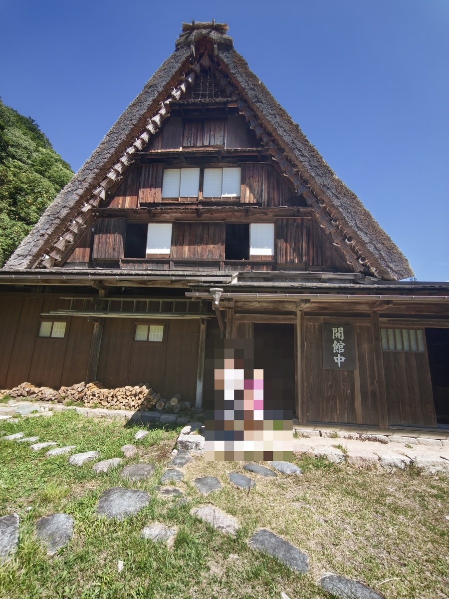 合掌造りの遠山家の前に立つ子どもたち