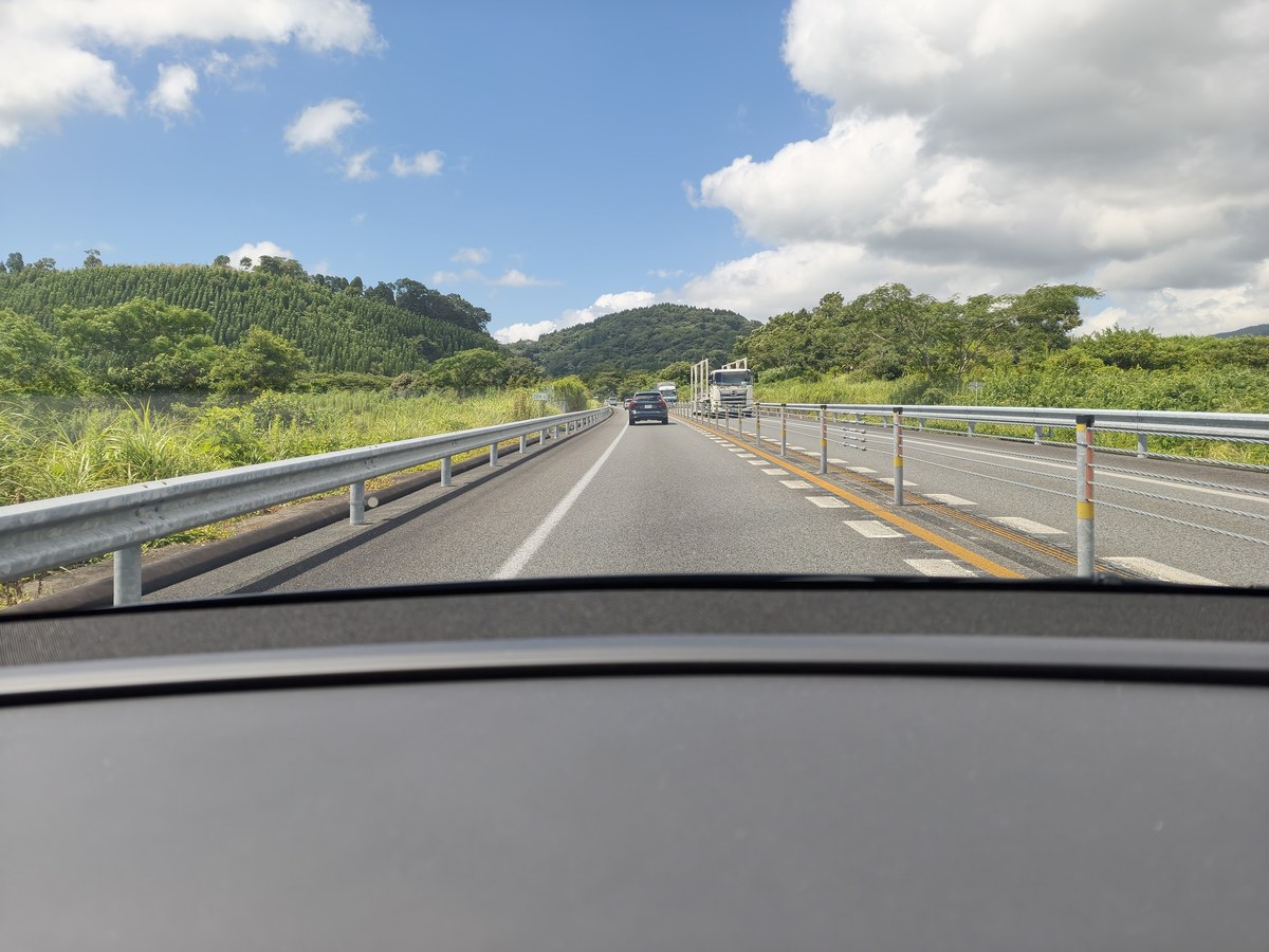 フロントガラス越しの東九州自動車道。片道1車線で前方にトラック