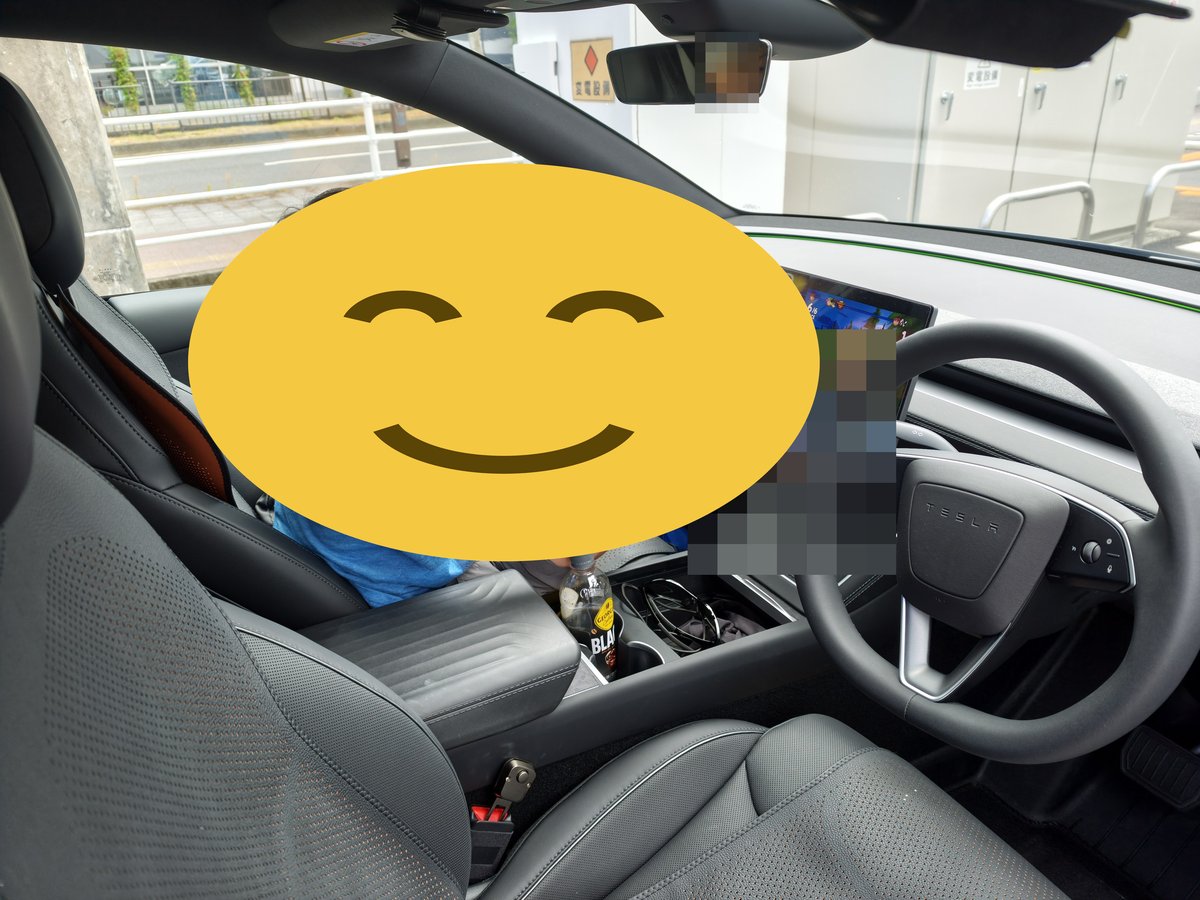 充電待ちの車内。運転席に座ってハンドルを握る子ども