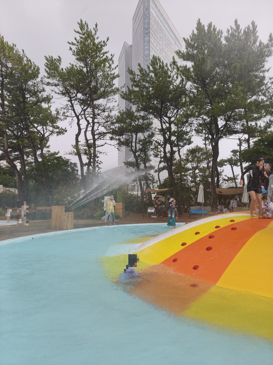 豪雨の中、スライダーを滑る子ども