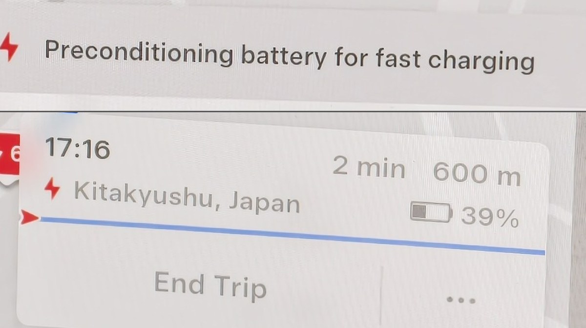 Model YLのナビ画面2枚。上は急速充電に向けたバッテリーの予熱中という表示、下は北九州まで2分・600m、残量39%