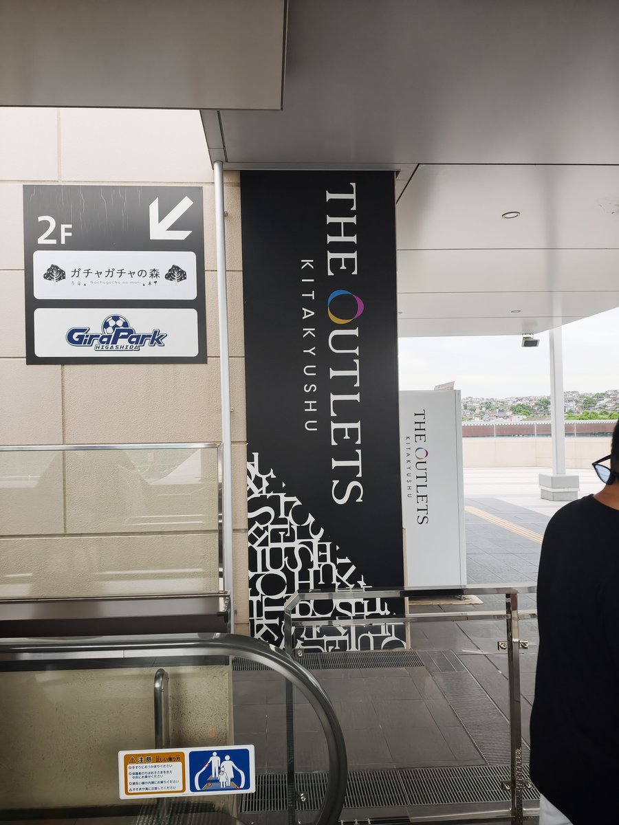 THE OUTLETS KITAKYUSHUの案内サイン。2階へのエスカレーター脇