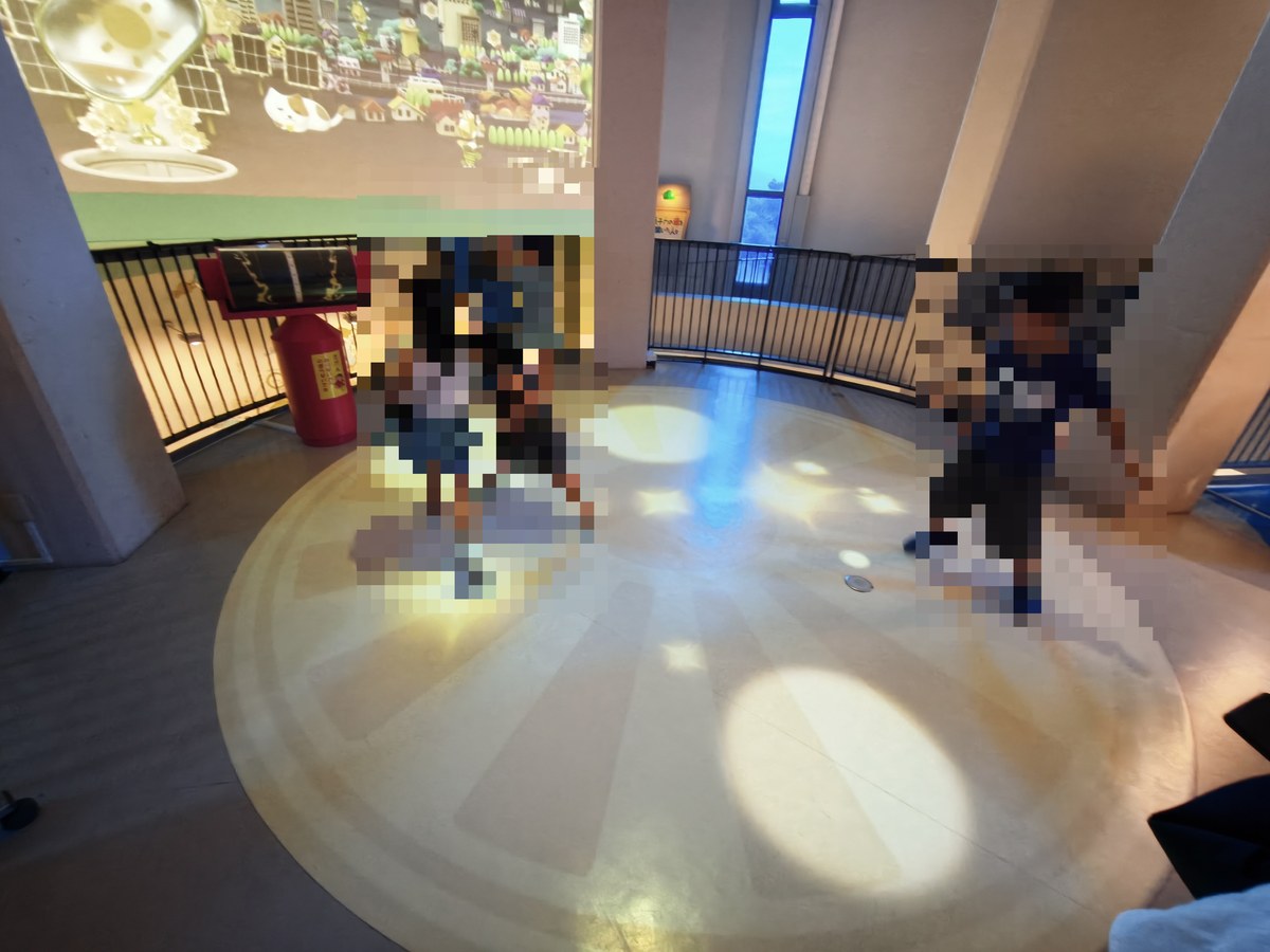 床が光る円形のエリアで走り回る子どもたち