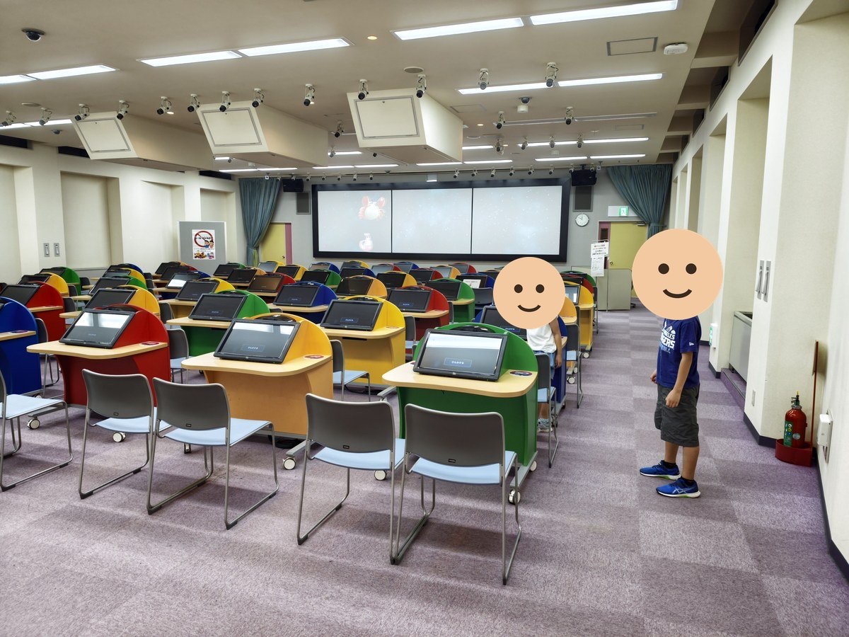 あっとシアターの座席。各席に回答用の端末が付いている