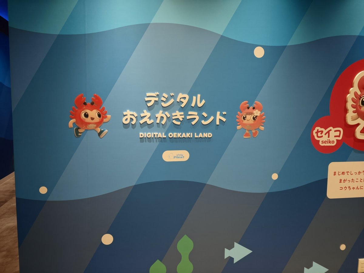デジタルおえかきランドの壁面サイン。カニのキャラクターが描かれている
